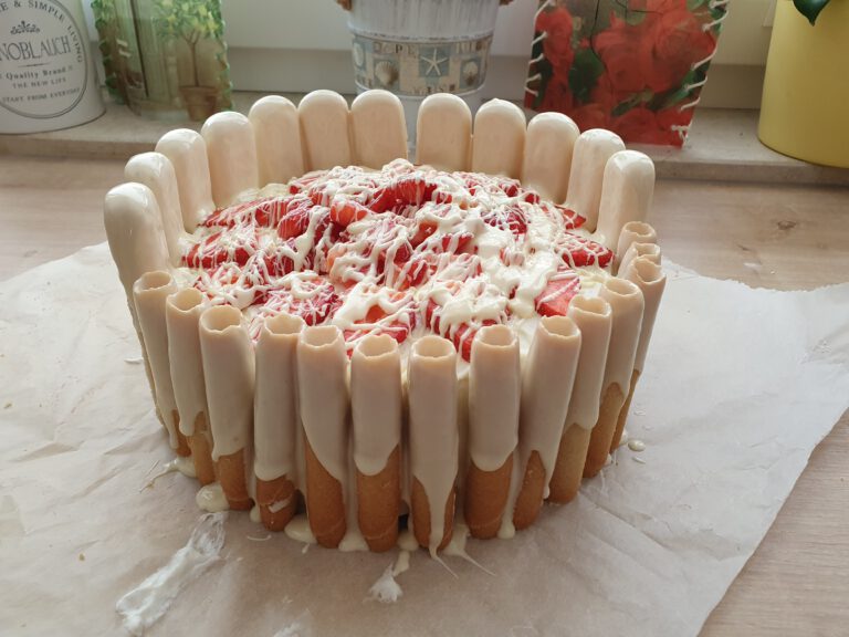 Eine Torte mit Erdbeeren, Keksen und weißer Schokolade.