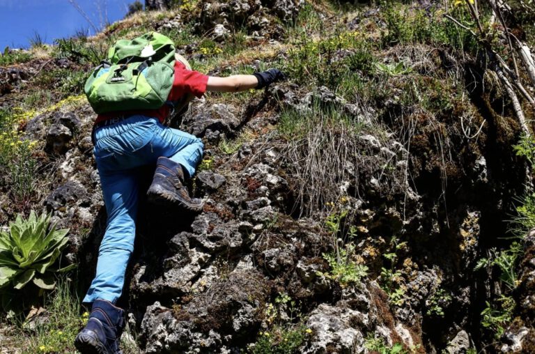 Ein Kind klettert einen Felsen hoch.