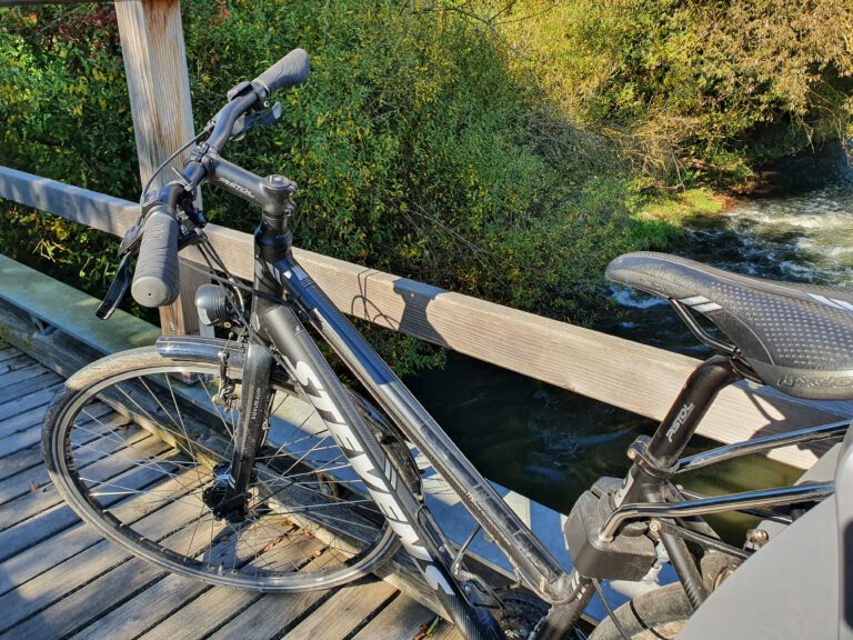 Ein schwarzes Fahrrad auf einer Holzbrücke.