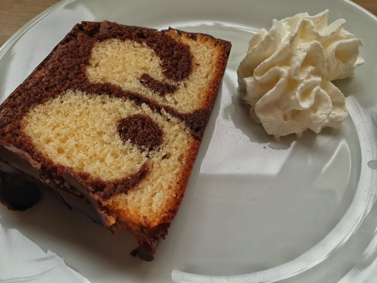 Ein Stück Marmorkuchen und ein Klecks Sahne.