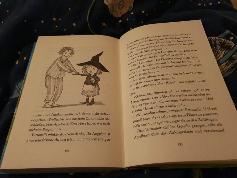 Ein offenes Kinderbuch auf dem eine Hexe zu sehen ist.