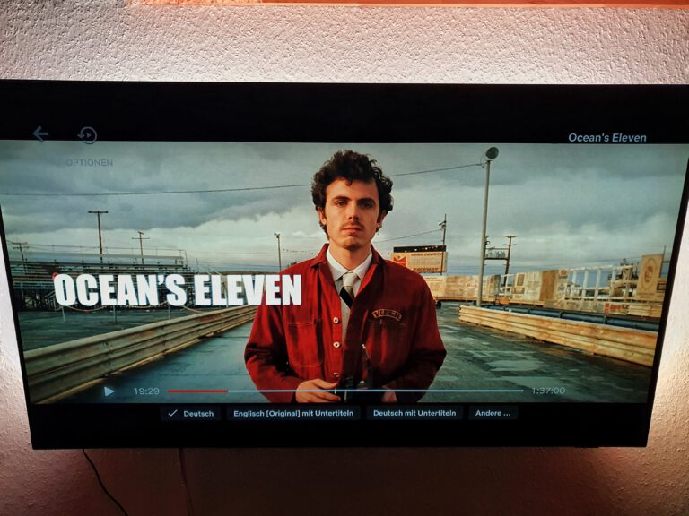 Ein Fernseher auf dem ein Mann zu sehen ist. Es steht Ocean's eleven drauf.