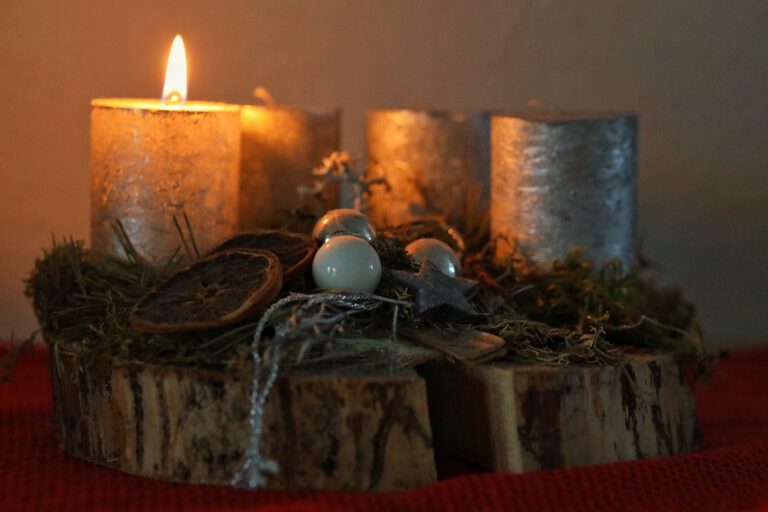 Ein Adventskranz auf dem die erste Kerze brennt.