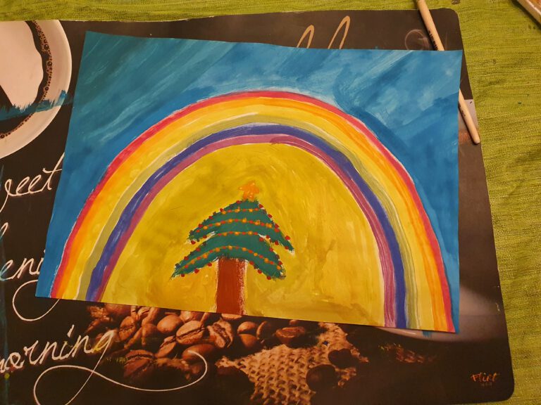 Ein buntes Bild mit einem Regenbogen und Weihnachtsbaum.
