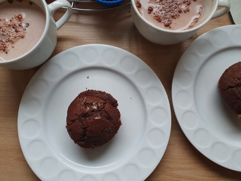 2 Teller mit Muffins und 2 Tassen mit Kakao.