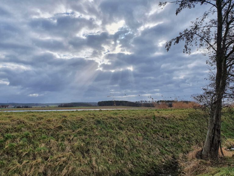 Graue Wolken durch die die Sonne blitzt.