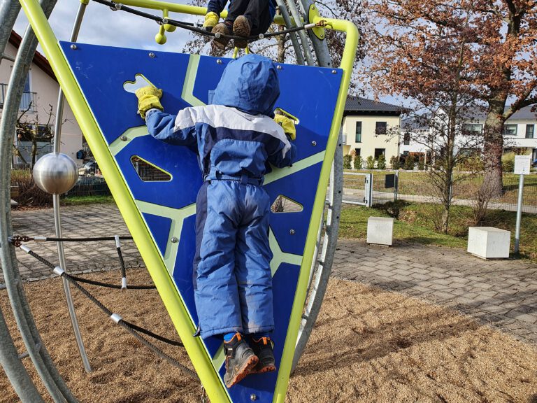 Kinder klettern auf ein Gerüst.