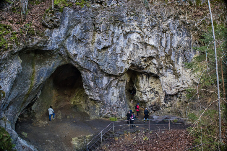 Große Felsen mit Löchern drinnen. Ein Geländer und ein paar Leute die klein wirken.