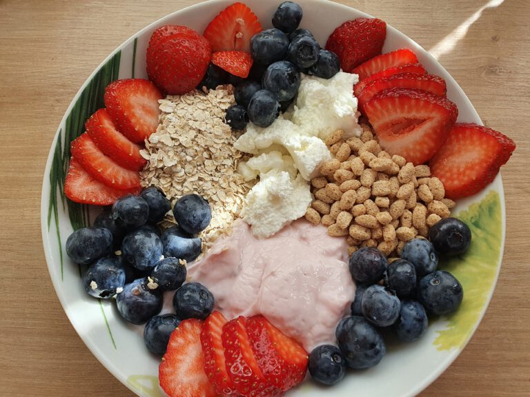 Eine Schüssel mit Joghurt, verschiedenen Obst und Quark.