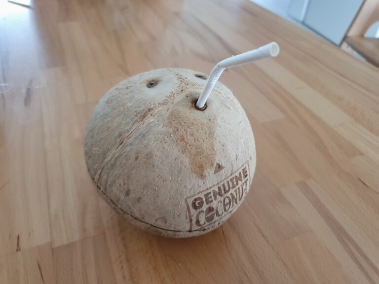 Eine Kokosnuss mit Strohhalm.