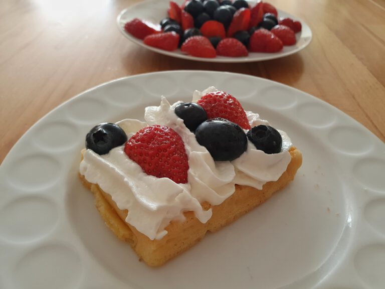 Eine Waffel mit Sahne und Früchten.