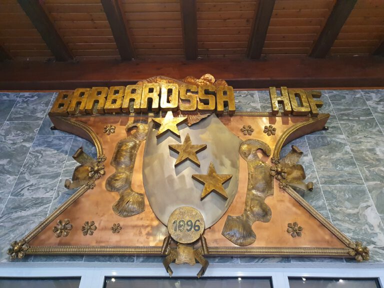 Ein großes Schild über einer Eingangstür mit 3 Sternen auf dem steht "Barbarossa Hof"