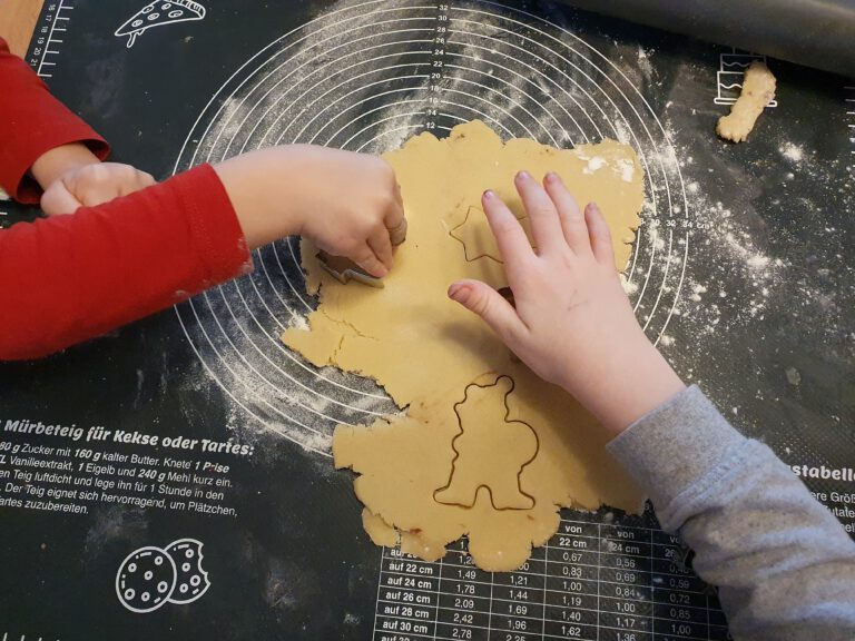 Kinder stechen Plätzchen aus.