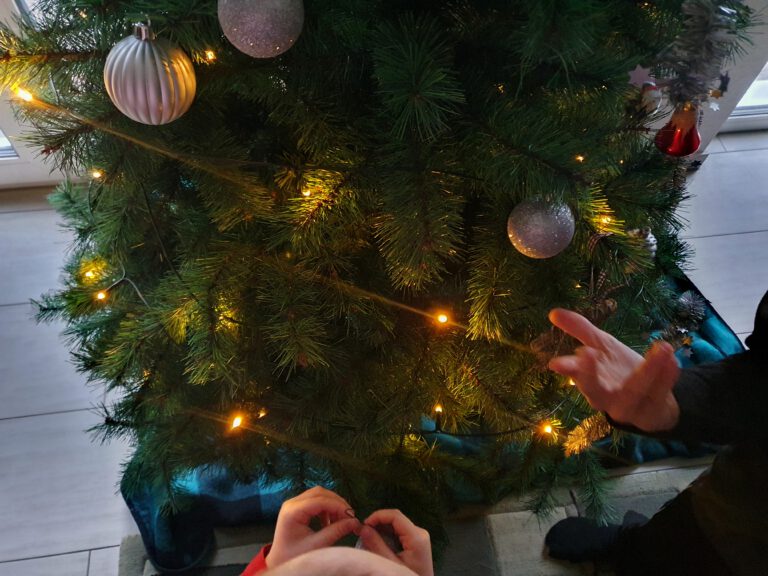 Ein Weihnachtsbaum mit Lichterkette und Kugeln.