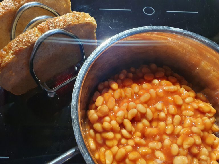 Ein Topf mit gebackenen Bohnen. Neben dran ist Brot.