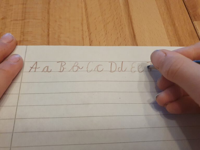 Eine Kinderhand die das ABC schreibt.