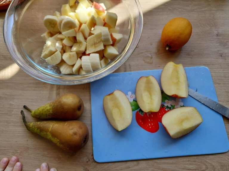 Eine Schale mit geschälten Obst. Daneben eine Zitrone, Äpfel und Birnen.