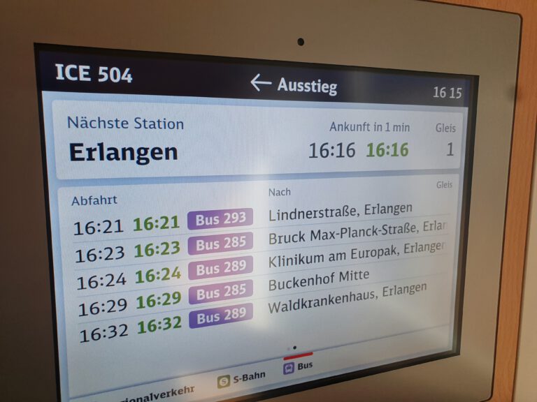 Der Monitor im Zug welcher den nächsten Halt Erlangen ankündigt.