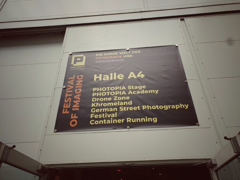 Ein großes Plakat über einer Tür mit der Aufschrift "Photopia Hamburg Halle A4"