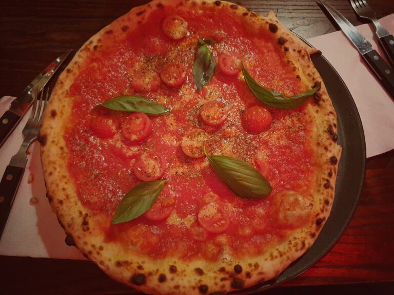Eine große Pizza mit Tomaten und Basilikum.