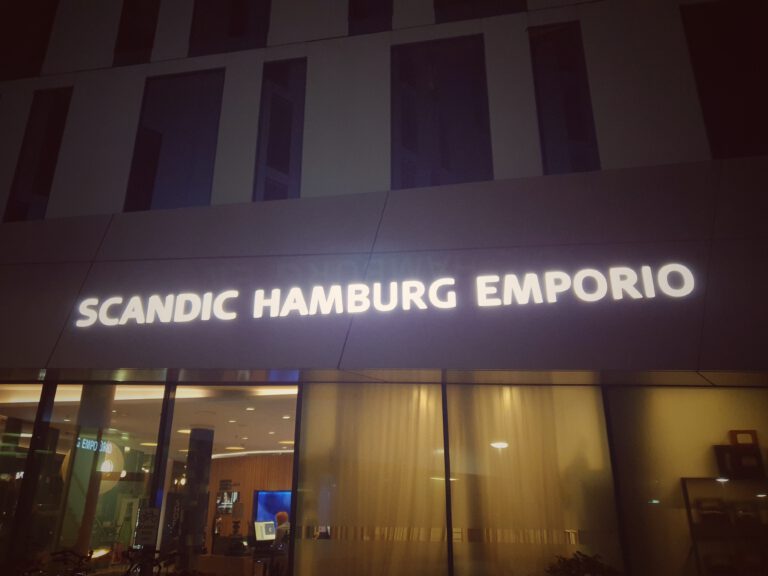 Ein Hotel auf dem in leuchtender Schrift "Scandic Hamburg Emporio" steht.