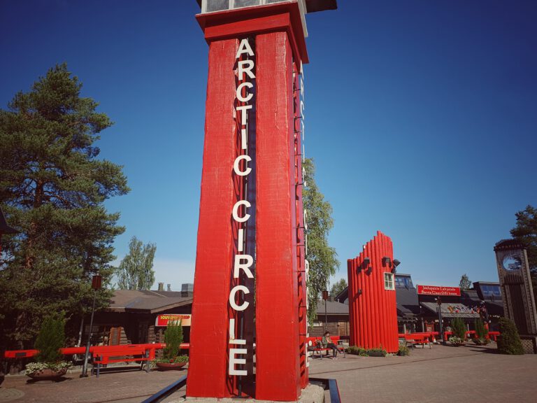 Eine rote Säule auf dem in roten Buchstanden von oben nach unten "Arctic Circle" steht.