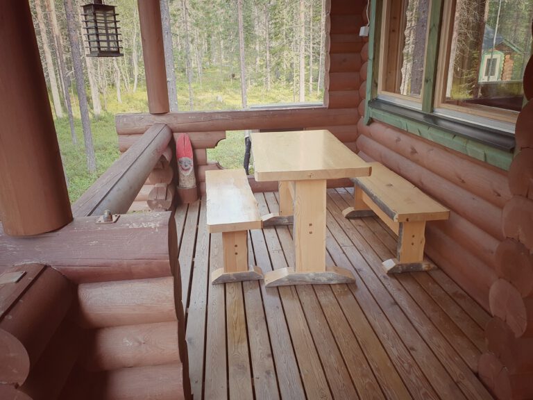 Eine Holzterrasse mit Tisch und zwei Bänken.