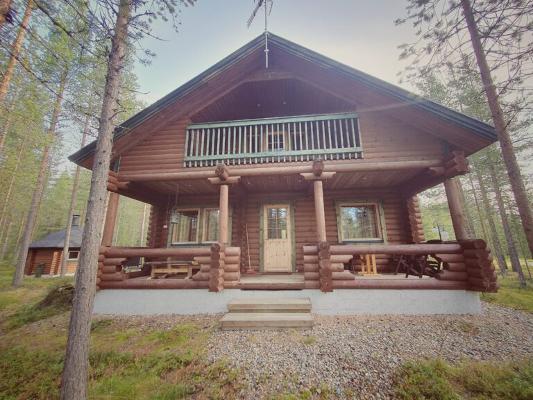 Eine Holzhütte in finnisch Lappland die mitten im Wald steht.